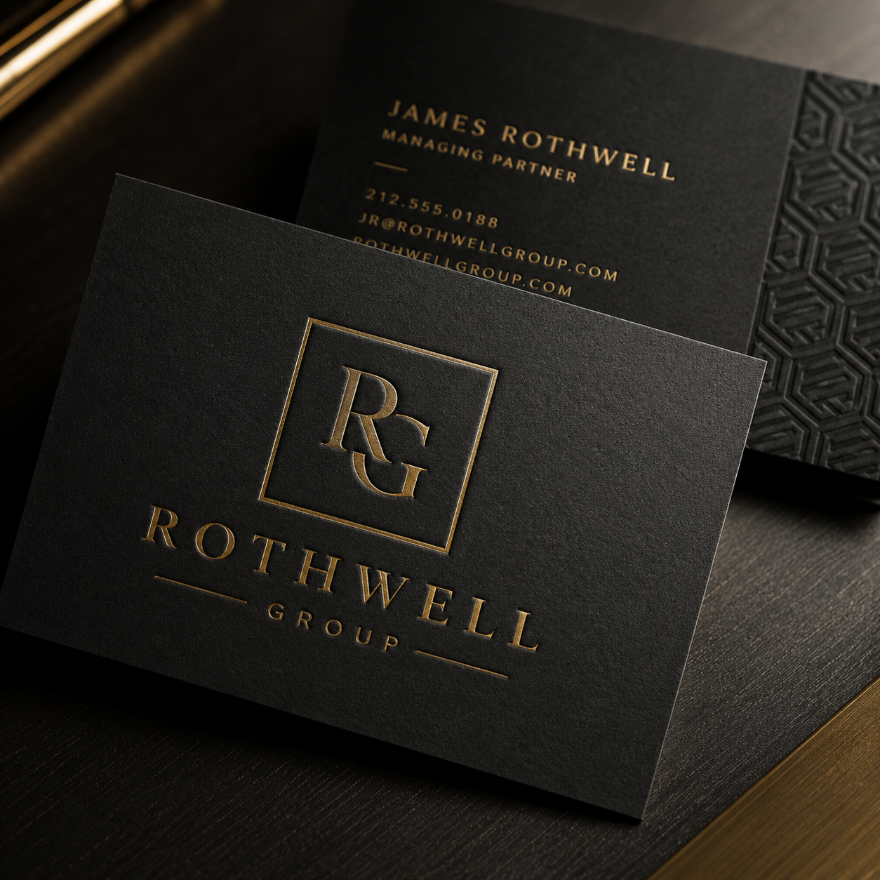Black business card with gold embossed text and logo for Rothwell Group on a dark surface.