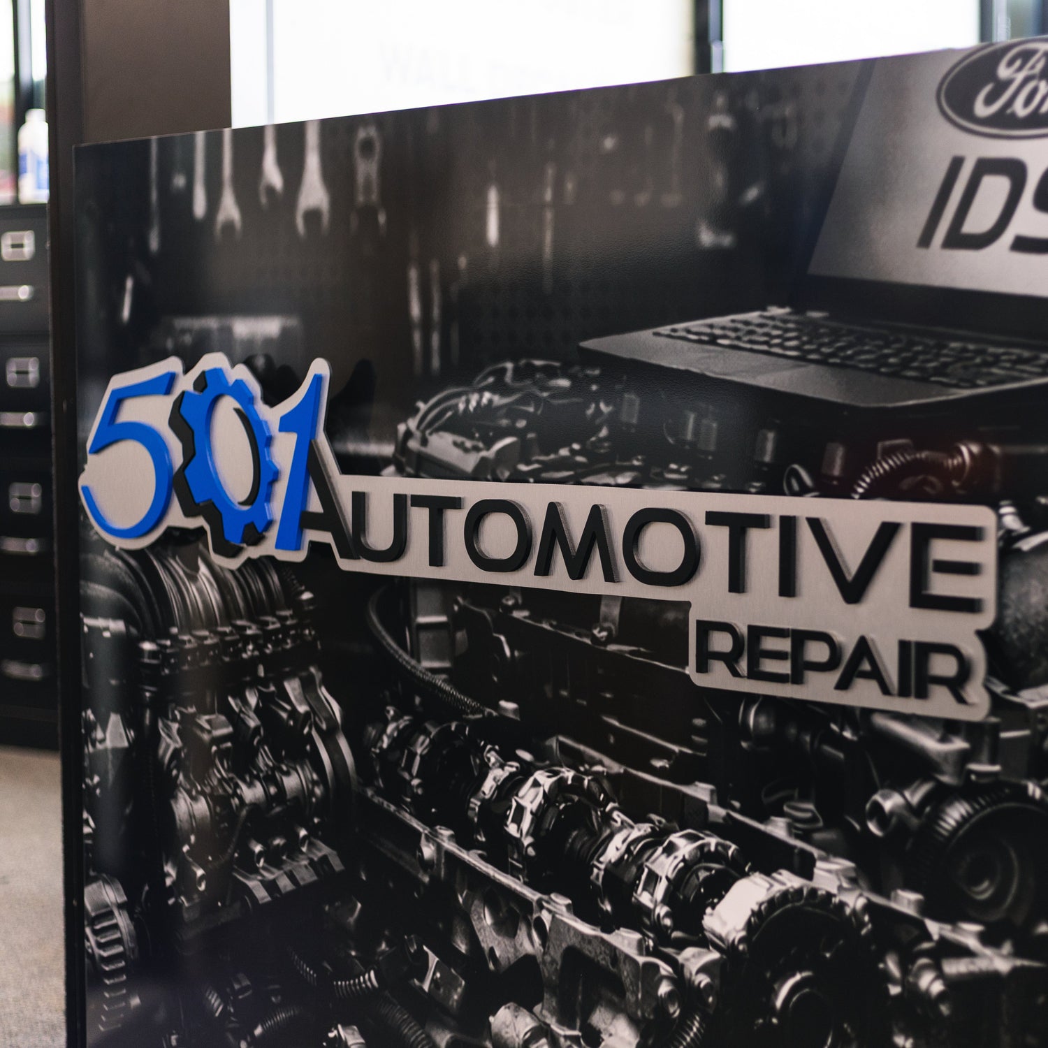 Automotive repair shop sign with engine graphic and '501 Automotive Repair' text.